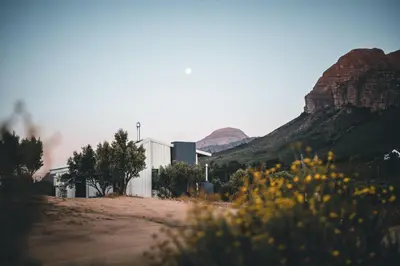 a building on a dirt road with mountains in the background at untether on Olive View in Wellington