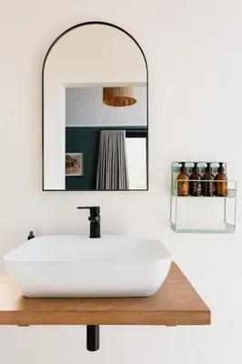 a bathroom with a white sink and a mirror at untether on Olive View in Wellington