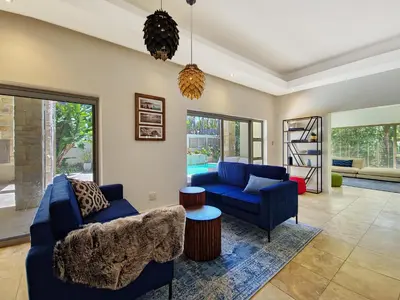 a living room with two blue couches and a table at Kite, Wind, Waves Beach Villa in Cape Town