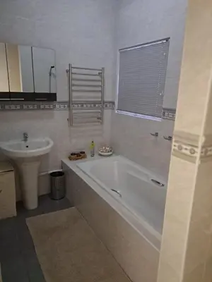 a white bathroom with a tub and a sink at 68 On Hofmeyr in Strand