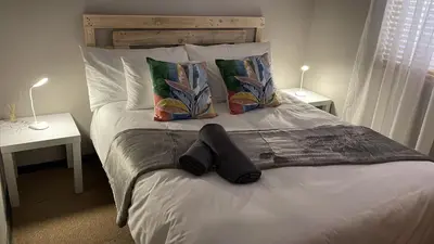 a bedroom with a bed with two tables and two lamps at 104 Horizon Bay Bloubergstrand in Bloubergstrand