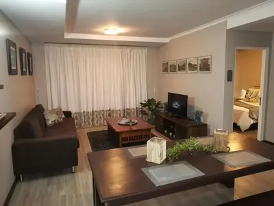 a living room with a couch and a table at 104 Horizon Bay Bloubergstrand in Bloubergstrand