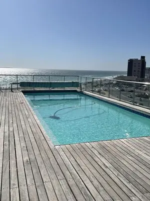 a swimming pool on a pier next to the ocean at 104 Horizon Bay Bloubergstrand in Bloubergstrand
