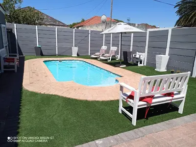 a small swimming pool in a yard with a bench at Stay Palm 1 in Cape Town