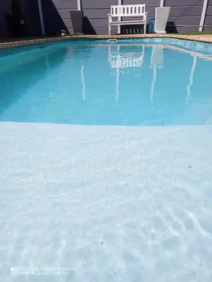 a large blue swimming pool with a chair in it at Stay Palm 1 in Cape Town