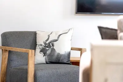 a cushion of a deer with antlers on a chair at Mountain and Sea Cottage in Hermanus