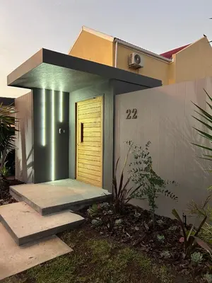 a house with a yellow door on the side of it at Green Oasis in Blouberg Hot Tub Kids Paradise in Cape Town