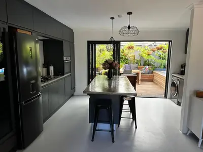 a kitchen with a table in the middle of a room at Green Oasis in Blouberg Hot Tub Kids Paradise in Cape Town