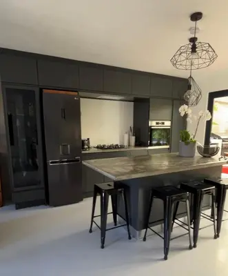 a kitchen with a large table and some stools at Green Oasis in Blouberg Hot Tub Kids Paradise in Cape Town