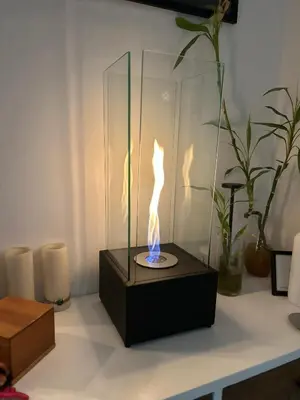 a lit candle in a glass box on a table at Green Oasis in Blouberg Hot Tub Kids Paradise in Cape Town