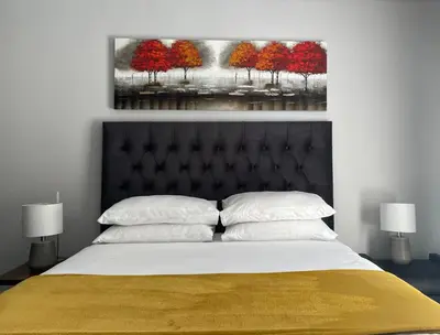 a bedroom with a bed with a painting on the wall at The CoziPlace Italia in Cape Town