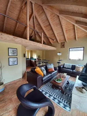 a living room with a couch and a table at Basco River Lodge Luxury Apartment in Grabouw