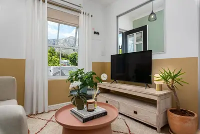 a living room with a flat screen tv and a table at The Tram Stop in Franschhoek