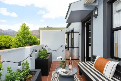 a balcony with a bench and a table at The Tram Stop in Franschhoek