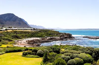 a view of a beach with the ocean and a train at Bayview 305A in Hermanus