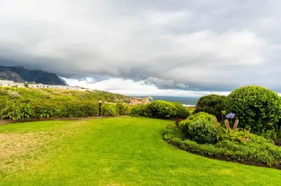 a green lawn with a view of the ocean at Bayview 305A in Hermanus