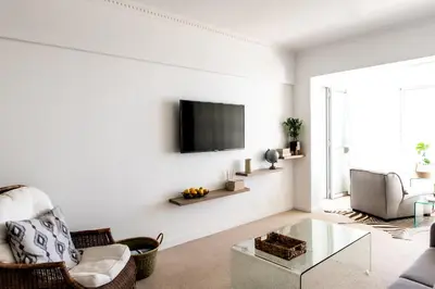 a living room with a tv on a white wall at Bayview 305A in Hermanus