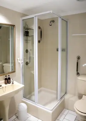 a white bathroom with a shower and a toilet at Bayview 305A in Hermanus