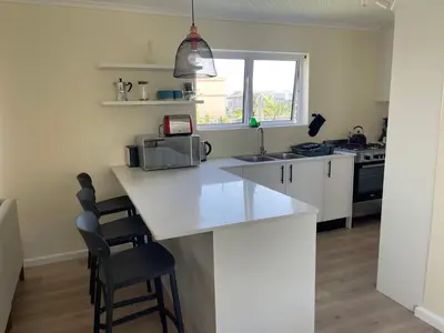 a kitchen with a white counter top and a sink at Silver Sunsets Self-Catering Apartments in Cape Town
