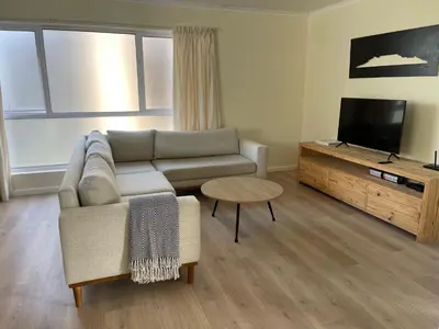 a living room with a couch and a tv at Silver Sunsets Self-Catering Apartments in Cape Town