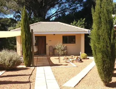 a small yellow house with trees in front of it at Gästehaus HelderbergView in Somerset West