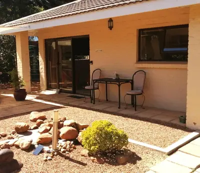 a patio with a table and chairs in front of a house at Gästehaus HelderbergView in Somerset West