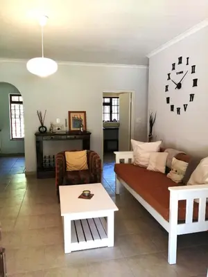 a living room with a couch and a table at Gästehaus HelderbergView in Somerset West