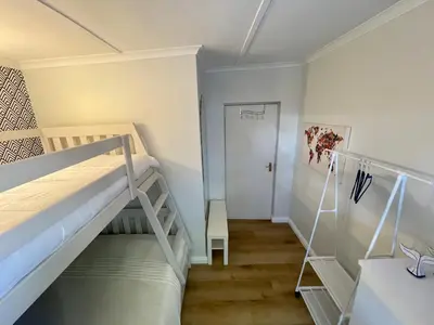 a bedroom with two bunk beds and a hallway at Adorable 2 Bedroom Cottage with spacious veranda in Hermanus