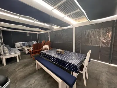 a dining room with a table and chairs in a tent at Adorable 2 Bedroom Cottage with spacious veranda in Hermanus