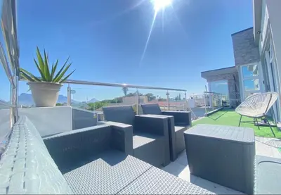 a patio with couches and chairs on a balcony at Kwaaami in Cape Town