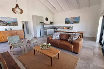 a living room with a couch and a table at Bestuis Cottages - Die Walvis in Klapmuts