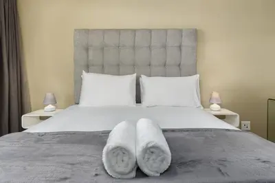 a bedroom with a large bed with towels on it at Knightsbridge 108 in Cape Town