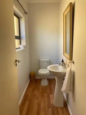 a bathroom with a white toilet and a sink at Johan-nest in Cape Town