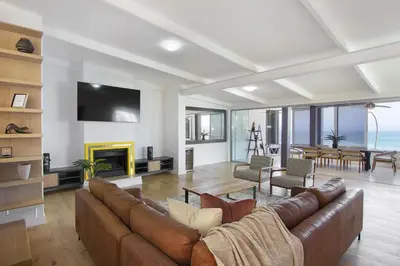 a living room with a couch and a fireplace at Atlantic Sky Villa in Gordonʼs Bay