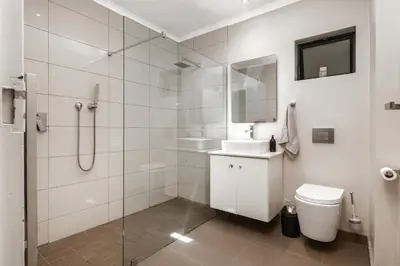 a bathroom with a shower and a toilet and a sink at Luxury Stellenbosch Villa in Stellenbosch