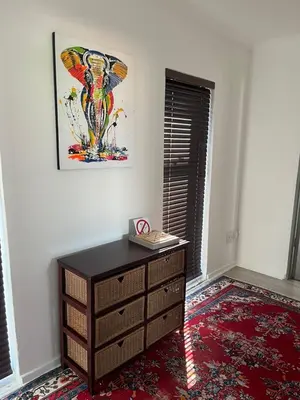 a room with a dresser and a painting on the wall at The Elephant House in Cape Town