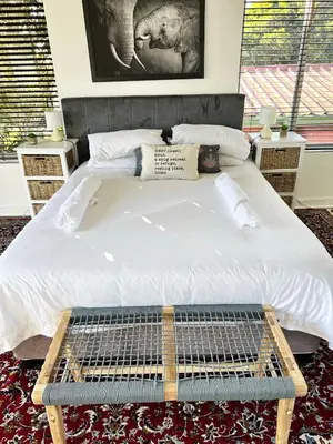 a bedroom with a large white bed and two windows at The Elephant House in Cape Town