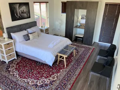 a bedroom with a large bed and a rug at The Elephant House in Cape Town