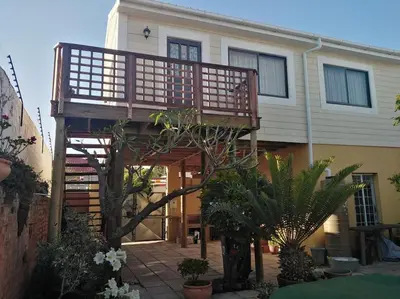 a house with a wooden deck in front of it at The Wee Hoose in Strand