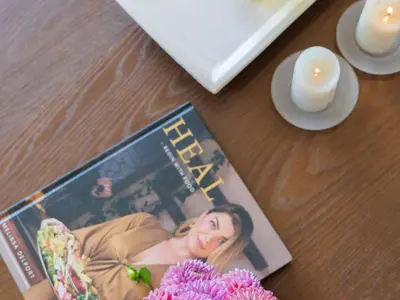 a magazine on a table with two candles and flowers at Dawn Mountains Farm in Simondium
