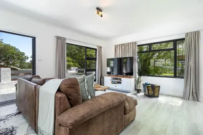 a living room with a couch and a tv at SAM's - Sea And Mountain in Hermanus