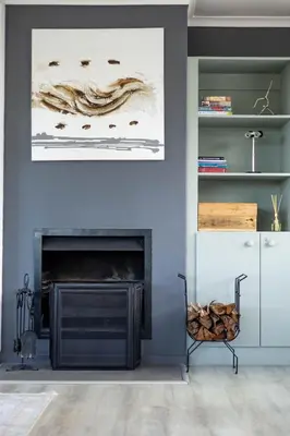 a living room with a fireplace and a painting at SAM's - Sea And Mountain in Hermanus