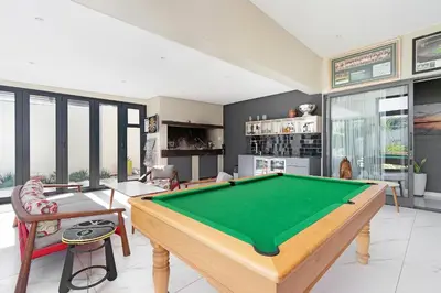 a living room with a pool table in it at On 8th Green Worthing Villa in Cape Town