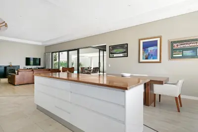 a kitchen and living room with a large island at On 8th Green Worthing Villa in Cape Town