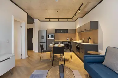 a living room and kitchen with a blue couch at Bridgewater View 415 in Cape Town