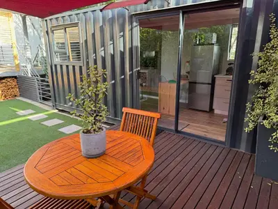 a wooden table with a potted plant on a deck at The Leopard Leaf Inn in Cape Town