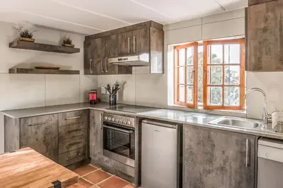 a kitchen with stainless steel appliances and a sink at Avemore Rare Gem with full Backup Power in Stellenbosch