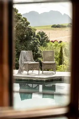 two chairs sitting next to a pool of water at Avemore Rare Gem with full Backup Power in Stellenbosch