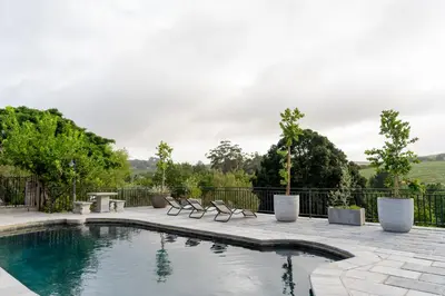 a swimming pool with chairs and a fence at Avemore Rare Gem with full Backup Power in Stellenbosch