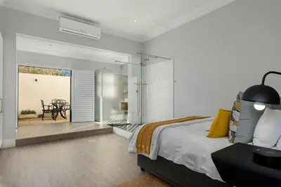 a bedroom with a bed and a table and a patio at Luxury Winetram getaway in Franschhoek